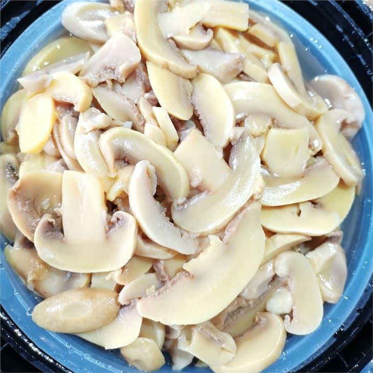 Fatias de cogumelos salgados em tambores grandes